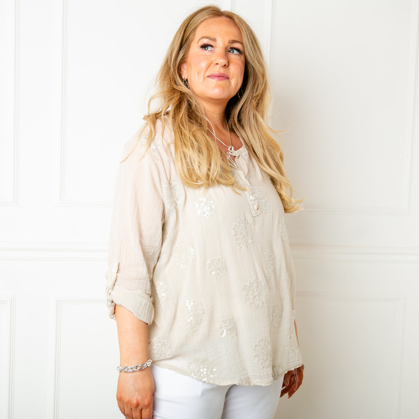 The stone cream Sheer Sequin Blouse with a v neckline and button detailing